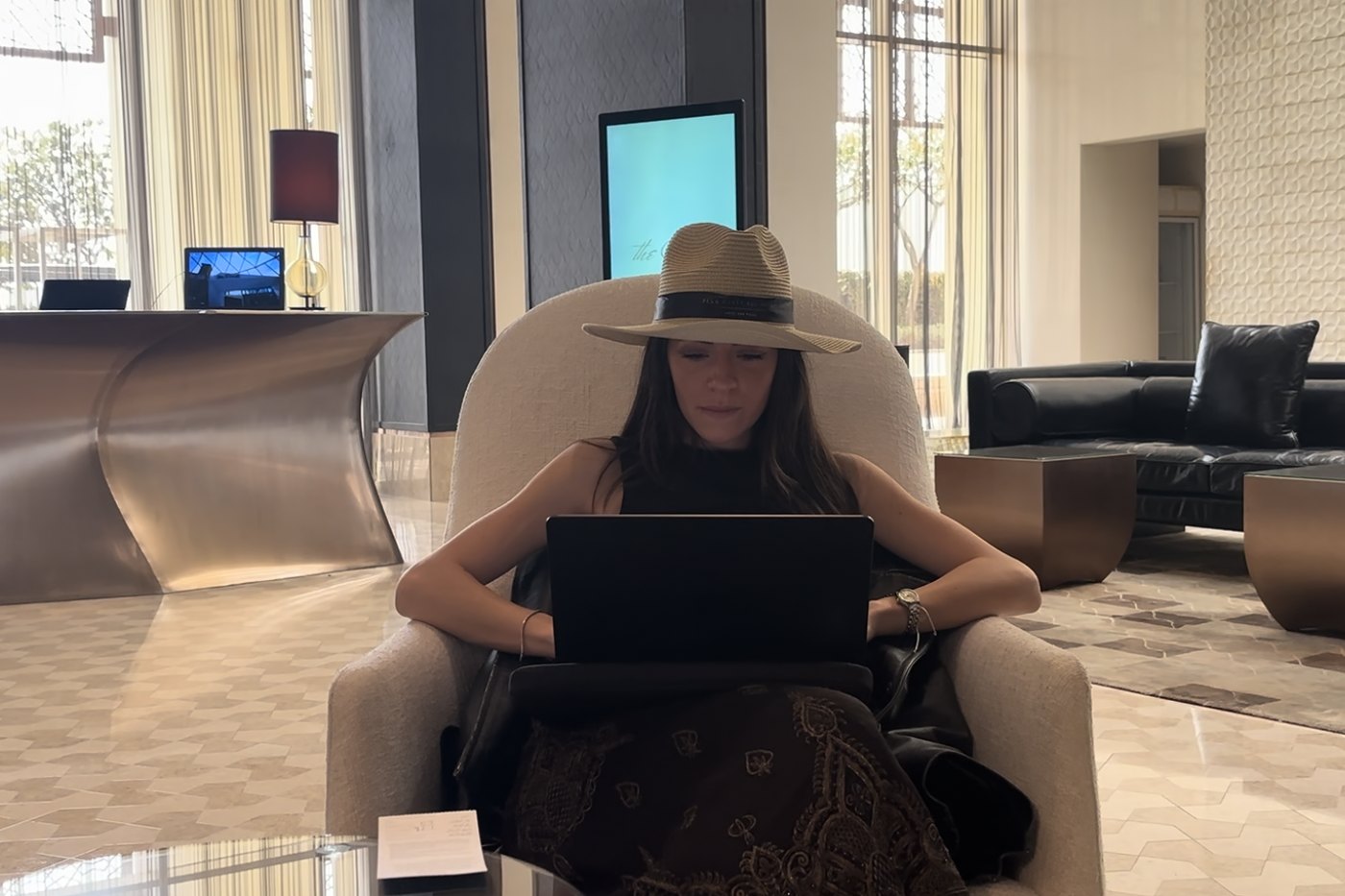 Giada working from a hotel lounge, laptop open
